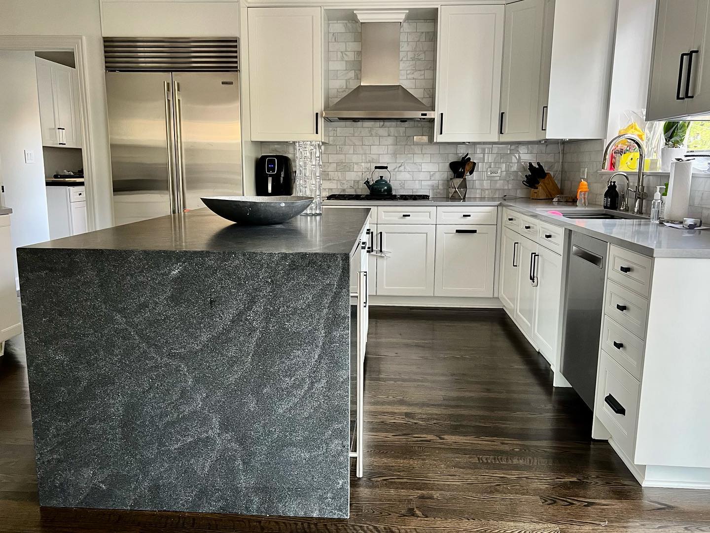 Custom dark stone waterfall island with carefully finished surfaces