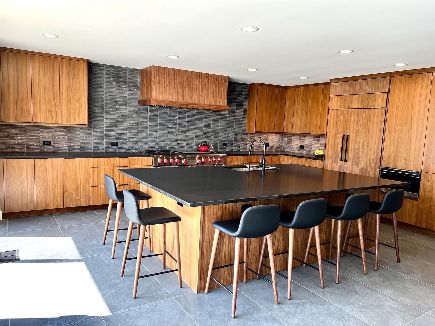 Custom dark stone island and countertops with warm wood cabinetry